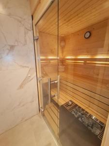 uma sauna com um relógio numa parede de madeira em Wilde Brise 2 Topniveau in Toplage mit Sauna em Norden