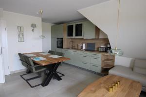 a kitchen and dining room with a table and a couch at Seeblick 3 in Norddeich