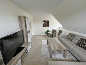 ein Wohnzimmer mit einem Sofa und einem Couchtisch in der Unterkunft Deichblick 2 - Traumhaft am Deich in Norddeich