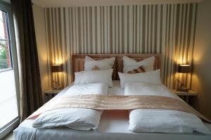 ノルトダイヒにあるKüstenblick 4のベッドルーム(白い枕の大型ベッド1台付)