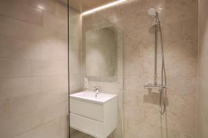 La salle de bains est pourvue d'un lavabo et d'une douche. dans l'établissement Seeblick 6 - Traumferien am Hafen, à Norddeich