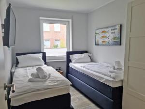 2 camas en una habitación pequeña con ventana en StrandART en Norddeich