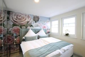 um quarto com uma cama com flores na parede em Seeblick 2 em Norddeich