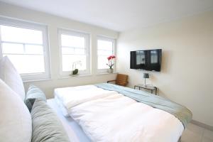 a white room with a couch and a tv at Seeblick 2 in Norddeich