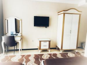 a room with a tv and a desk and a cabinet at Hotel Seref in Yalova