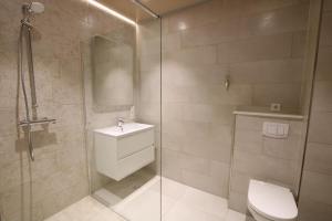 a bathroom with a toilet and a glass shower at Seeblick 5 - Luxus am Hafen in Norddeich +26 photos