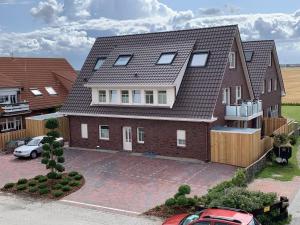 a house with a car parked in a driveway at Seeblick 5 - Luxus am Hafen in Norddeich