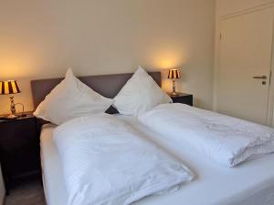 zwei weiße Kissen auf dem Bett in der Unterkunft Die Zimmerei 2 - Luxus in Greetsieler Toplage in Krummhörn