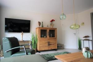 a living room with a tv and a wooden cabinet at Seeblick 1 in Norddeich