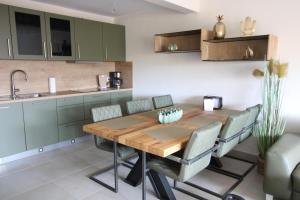 a kitchen with a wooden table and gray chairs at Seeblick 1 in Norddeich