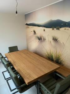 comedor con mesa de madera y sillas en Landblick 4 - Luxusferienhaus für bis zu 7 Personen, en Norddeich