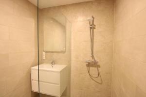 La salle de bains est pourvue d'une douche, de toilettes et d'un lavabo. dans l'établissement Landblick 4 - Luxusferienhaus für bis zu 7 Personen, à Norddeich
