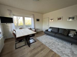 ein Wohnzimmer mit einem Sofa und einem Tisch in der Unterkunft Deichblick 4 in Norddeich- Urlaub und Erholung am Strand in Norden