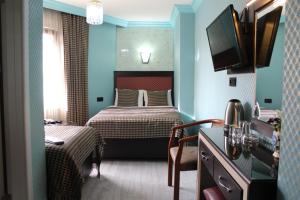 um quarto com uma cama e uma televisão num quarto em Hotel Falcon em Istambul
