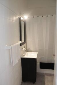 a white bathroom with a sink and a mirror at mardel house in Mar del Plata +13 photos