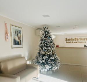 a christmas tree in the corner of a room at Santa Barbara hotel & apartments in Bellaria-Igea Marina