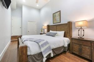 1 dormitorio con 1 cama grande y cabecero de madera en Modern 4BR Living in Downtown NOLA, en Nueva Orleans