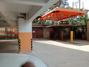 een uitzicht op een gebouw met een oranje paraplu bij Spacious Studio in Kileleshwa Nairobi in Nairobi