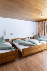 3 Betten in einem Zimmer mit Holzböden in der Unterkunft Haus Kappeller in Bach