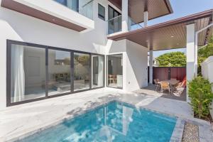 an indoor swimming pool in the backyard of a house at 可提供早餐的三卧私家泳池家庭别墅 in Ban Huai Yai