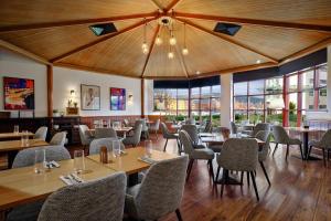 a restaurant with wooden ceilings and tables and chairs at Delta Hotels by Marriott Swansea in Swansea