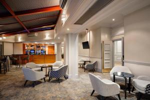 un vestíbulo con sillas y mesas y un bar en Delta Hotels by Marriott Swansea en Swansea