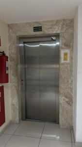 Um elevador de metal num edifício com um sinal. em Europa Vista Mar em João Pessoa