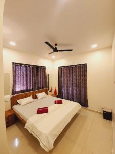 a bedroom with a large bed with a ceiling fan at Hotel Mahadev Family Lodging and Boarding in Neral