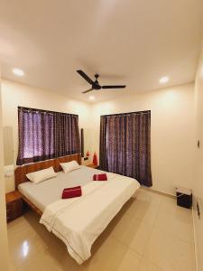 a bedroom with a large bed with two windows at Hotel Mahadev Family Lodging and Boarding in Neral
