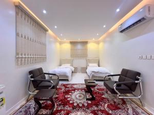 salon z 2 łóżkami i 2 krzesłami w obiekcie شقة العقيق عروة alaqeeq apartments w Medynie