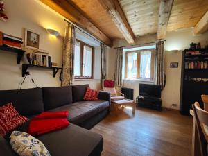 ein Wohnzimmer mit einem Sofa und einem TV in der Unterkunft Hostdomus - Via Roma Suite in Cesana Torinese
