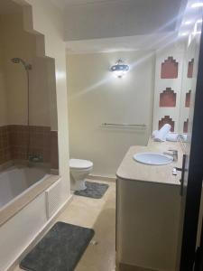 une salle de bain avec un lavabo, une baignoire et des toilettes dans l'établissement Appartement Ensoleillé vue Piscine, à Marrakech