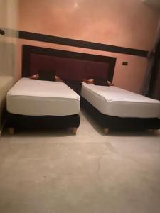2 lits sont installés dans une pièce avec toilettes dans l'établissement Appartement Ensoleillé vue Piscine, à Marrakech