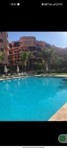une grande piscine bleue devant un immeuble dans l'établissement Appartement Ensoleillé vue Piscine, à Marrakech 14 autres photos