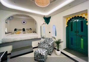 a bedroom with a bed with a green door and a chair at Moustache Udaipur in Udaipur