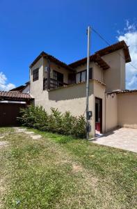 een huis met een grasveld ervoor bij Casa temporada em Paraty famíliar in Paraty