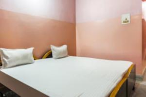 a bedroom with a large white bed with two pillows at Indra Bhawan Lodge, Cuttack in Cuttack