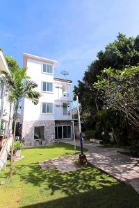 un bâtiment blanc avec un palmier en face dans l'établissement ZAYN Samui Hotel, à Bophut 