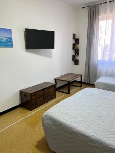 a bedroom with a bed and a flat screen tv at Gaslini Sea House in Genoa