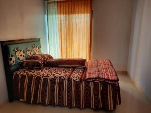 a bed sitting in a room with a window at Villa Bukit Nirwana in Bogor