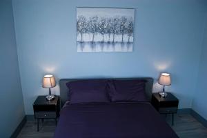 ein Schlafzimmer mit einem lila Bett mit zwei Lampen an Tischen in der Unterkunft Family Friendly Contemporary House with Pool in Las Vegas
