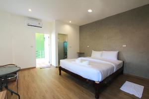 Un dormitorio con una gran cama blanca y una mesa en ZAYN Samui Hotel en Bophut 
