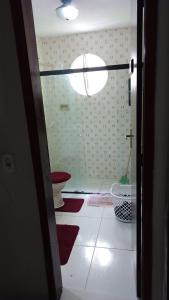 La salle de bains est pourvue de toilettes et de tapis rouges. dans l'établissement Casa do Braga, à Cabo Frio