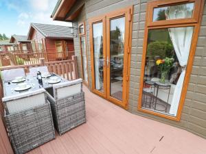 a patio with a table and chairs on a balcony at 10 Poppy Lodge in Richmond