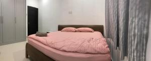 a bedroom with a pink bed with two pillows at Modern 3 bedrooms House, Walking distance to Kulim Town by Mr Homestay in Kulim