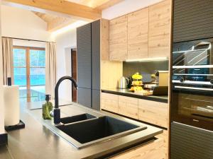 a kitchen with a sink and a stove at Alpen Luxury Lodge, MARIAZELL in Mariazell