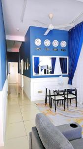 une salle à manger avec une table et un mur bleu dans l'établissement Homestay By MSH, à Seri Iskandar
