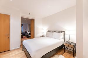 a bedroom with a large white bed and a living room at Elegant 2 Bed Flat in Knightsbridge in London