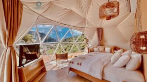 a bedroom with a bed in a tent with a large window at Unique Stays at Karuna El Nido - The Dome in El Nido