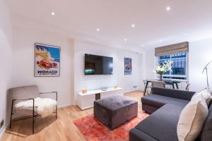 a living room with a couch and a table at Elegant 2 Bed Flat in Knightsbridge in London